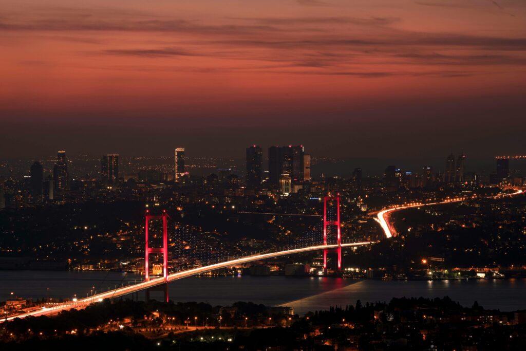 pexels-photo-7386650-7386650 Stunning night view of the illuminated Bosphorus Bridge and Istanbul skyline under a red sky.